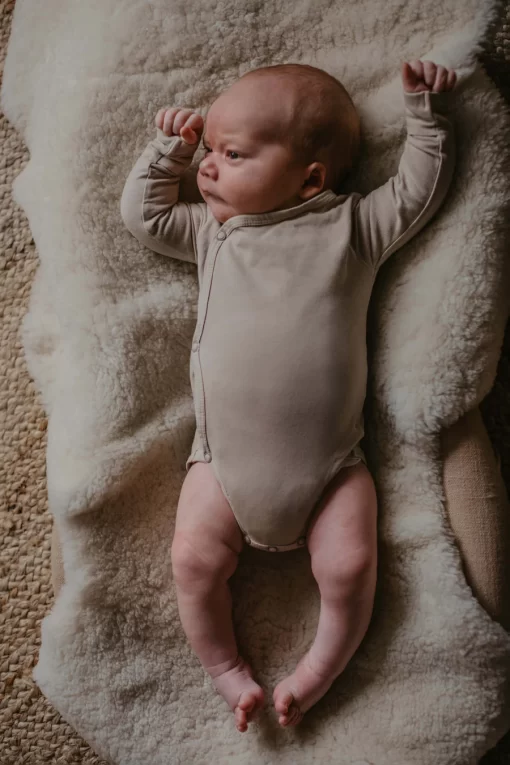 baby with beige bodysuit