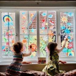 children draw with window chalk on window