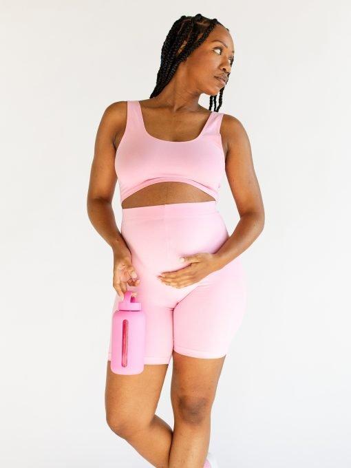 zwangere vrouw met roze glazen drinkfles