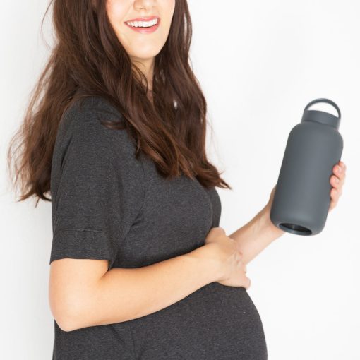 zwangere vrouw met glazen drinkfles donkergrijs