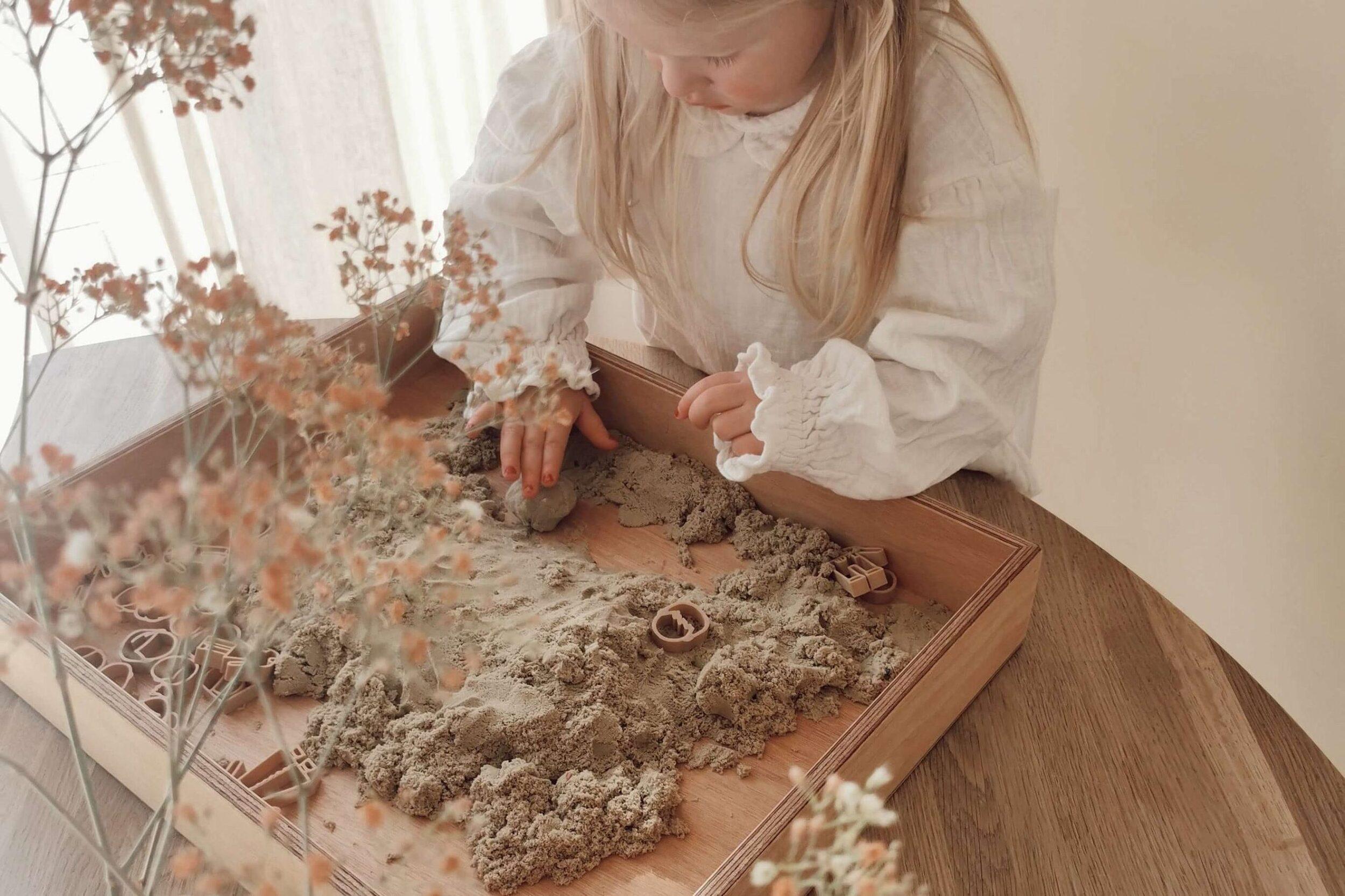 playing child with wooden play tray